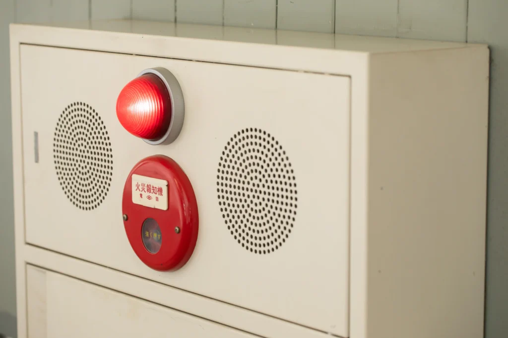 マンション共用部に設置された非常ベルの発信機と警報ランプ