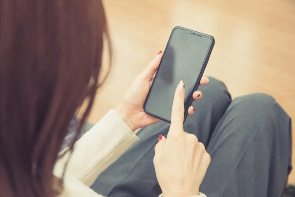 スマホで管理会社へ連絡しようとしている女性の手元